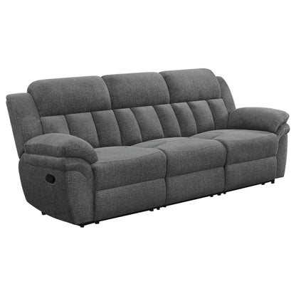 Dark gray reclining sofa with tufted back cushions and padded armrests