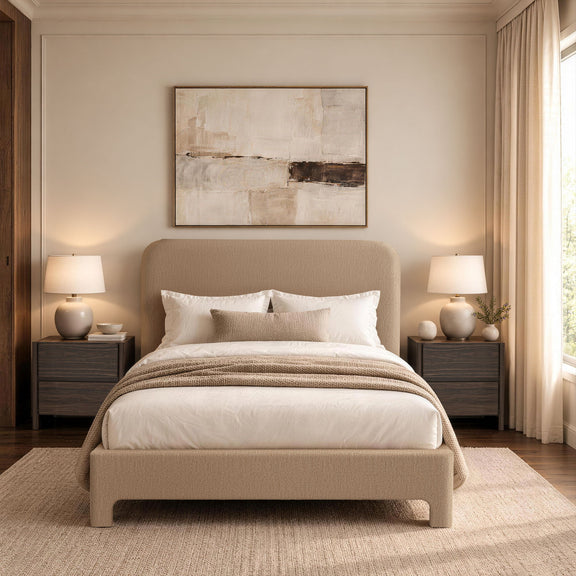 Light brown upholstered bed with rounded headboard, white duvet, pillows, and striped throw