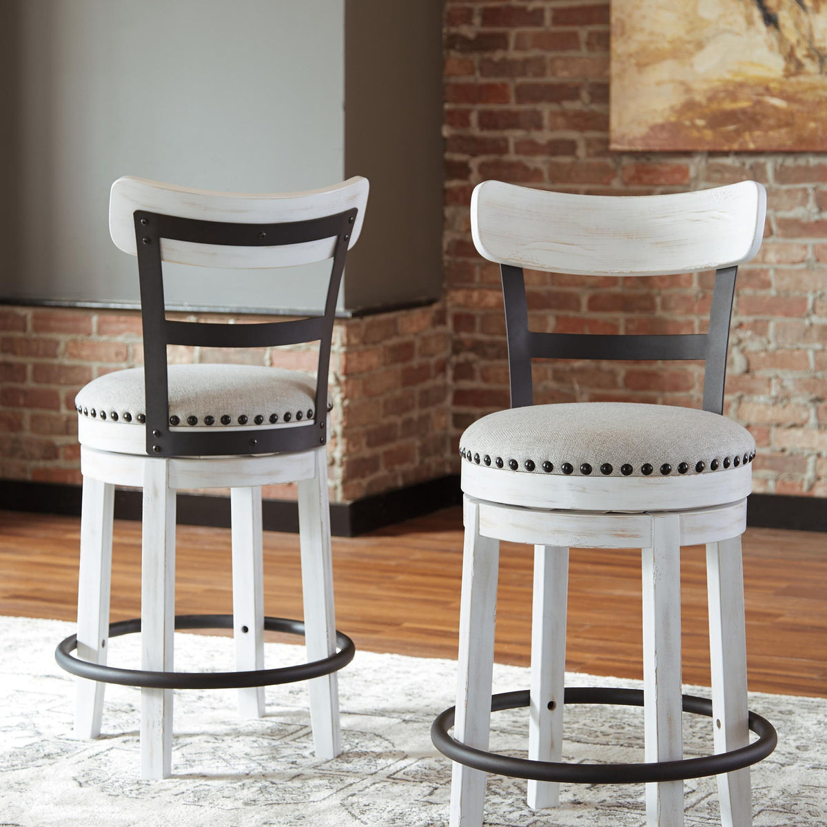 Two white swivel bar stools with full backs, studded upholstered seats, and base rings