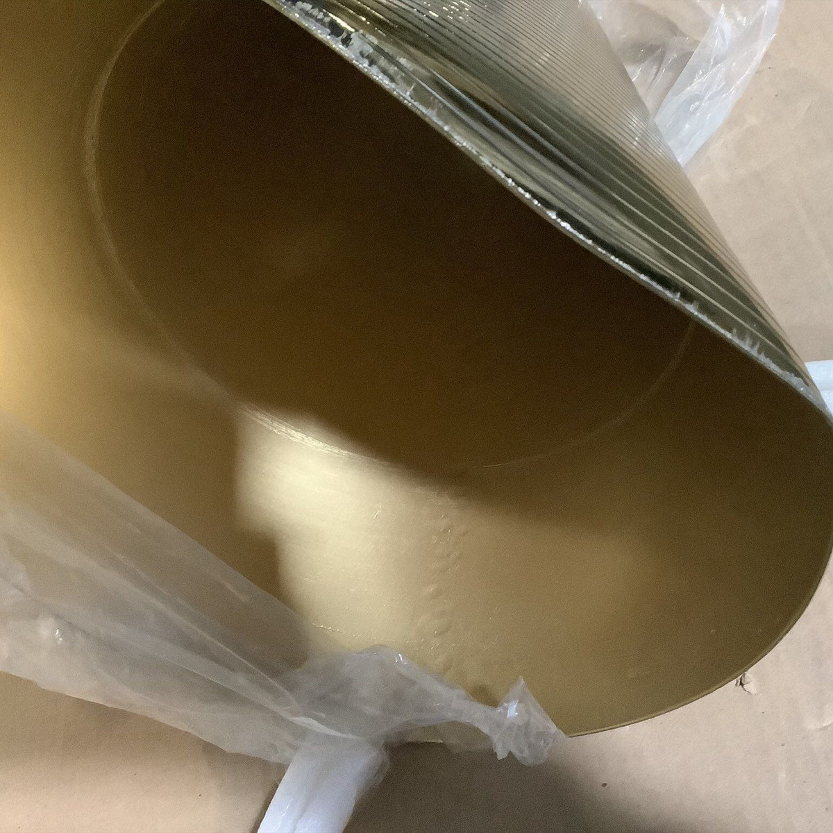 Gold-tone pedestal base underside with protective wrap on table frame