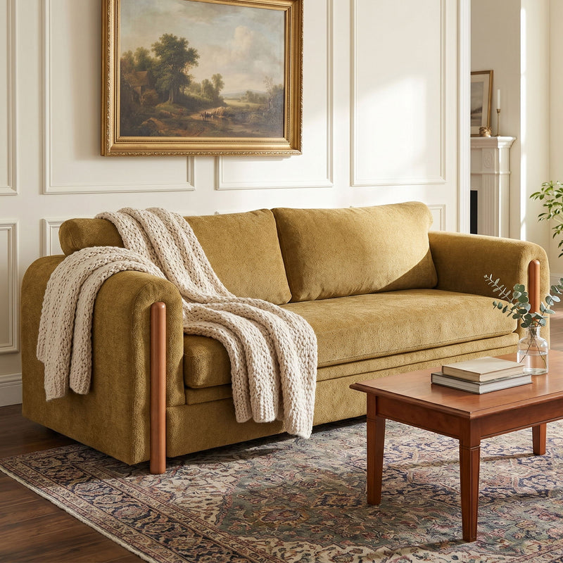 Brown 3-seat upholstered couch with wooden arms and beige knitted throw