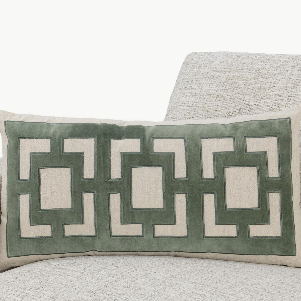 Light beige pillow with green geometric applique on a rectangular front