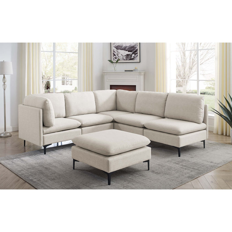 Beige L-shaped sectional with ottoman and tall black legs, rounded arms