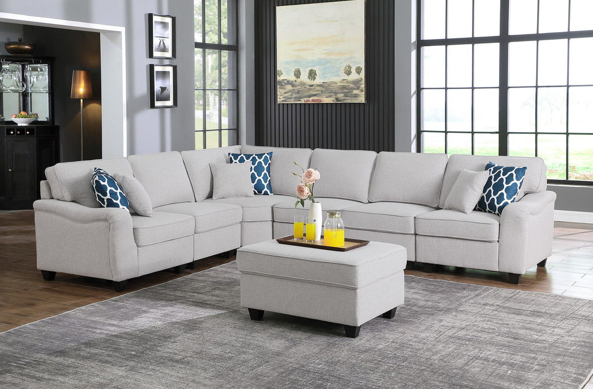 Gray modular sectional sofa with ottoman and blue geometric pillows, L-shape seating