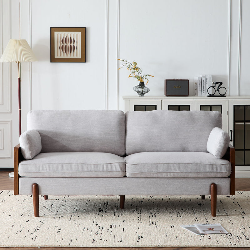 Light gray sofa with dark wood arms and legs, styled with decor in a room