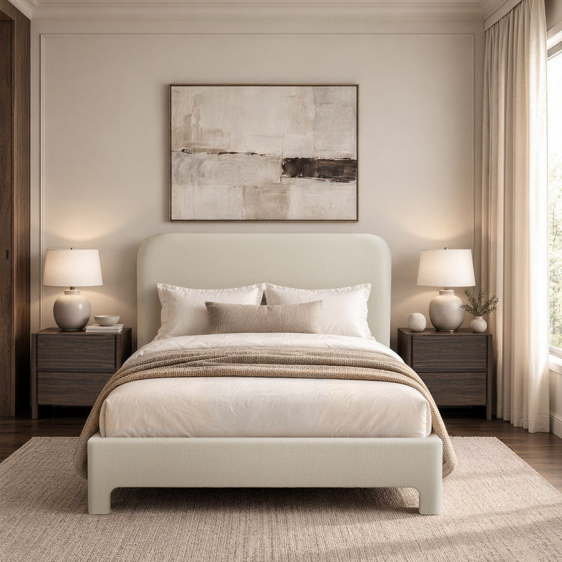 Beige upholstered bed with rounded headboard, white bedding, and striped throw blanket