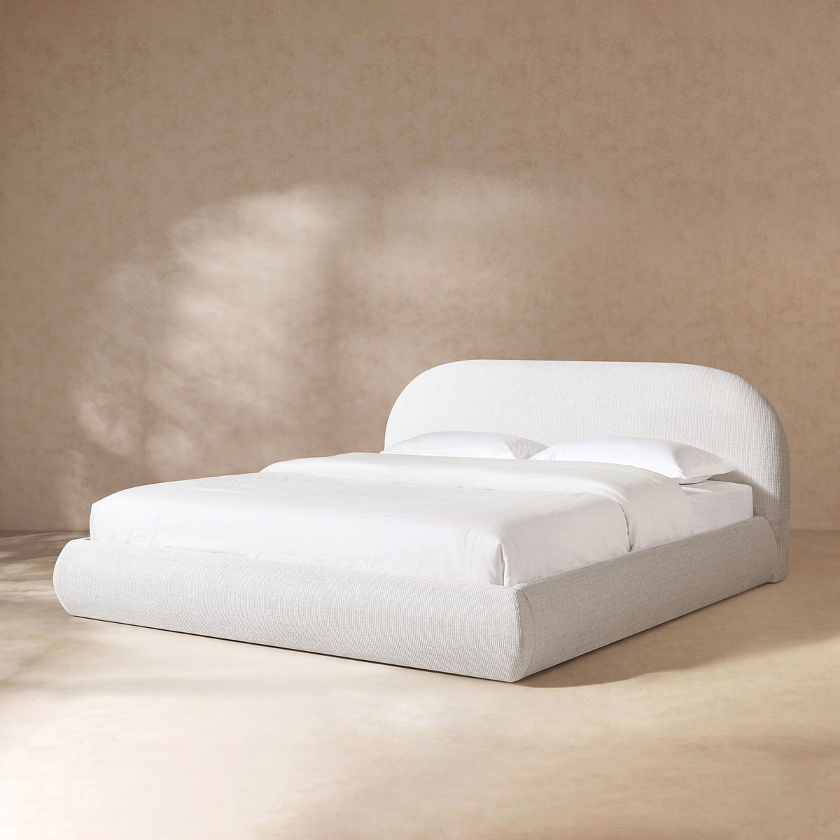 Upholstered platform bed in white fabric with padded headboard and slat support