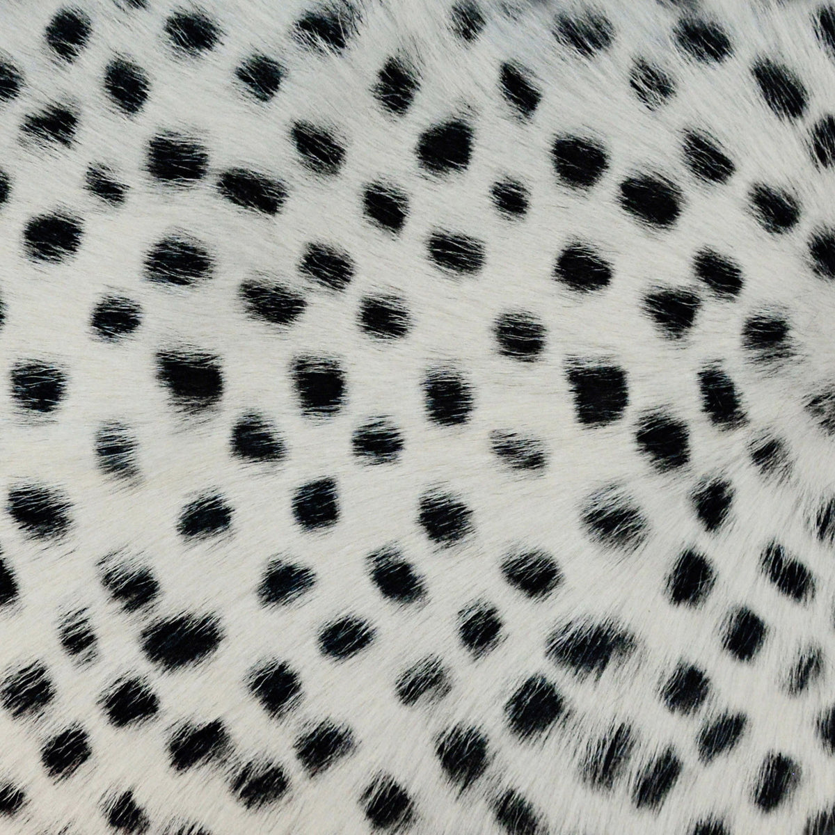 White goatskin-look pillow fabric with dense black dots, soft plush texture