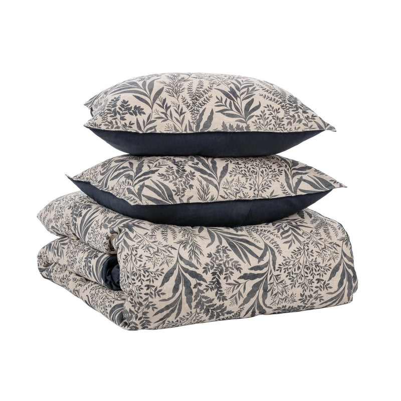 Denim blue leaf-pattern duvet and pillowcases stacked with dark backing