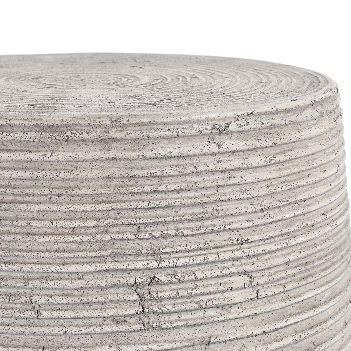 Gray outdoor table top edge close-up with concentric grooves and speckled finish