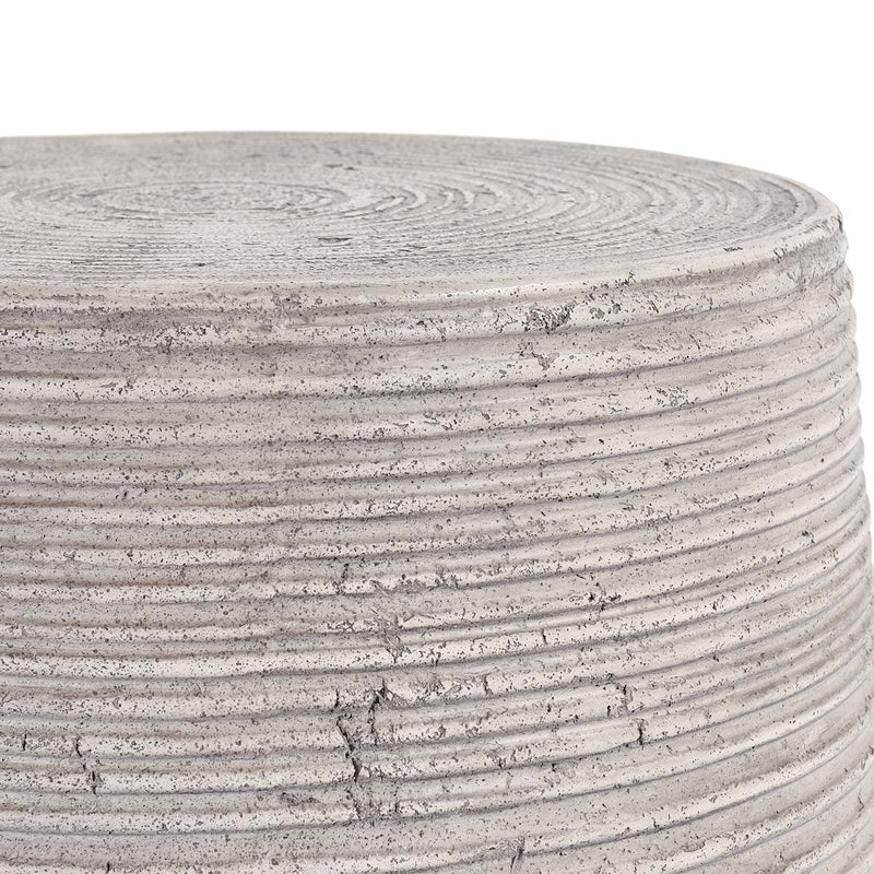 Gray outdoor table top edge close-up with concentric grooves and speckled finish
