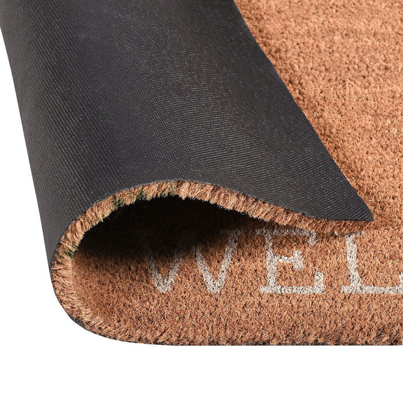 Coir doormat with dark backing, fringed edge, and partial “WELCOME”