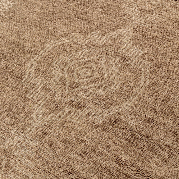 Desert brown hand-knotted rug close-up with geometric medallion motif.
