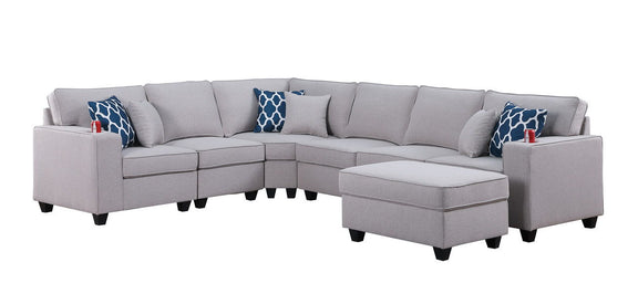 Gray sectional sofa with ottoman chaise and blue patterned accent pillows, chaise on right