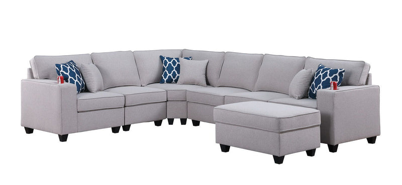 Gray sectional sofa with ottoman chaise and blue patterned accent pillows, chaise on right