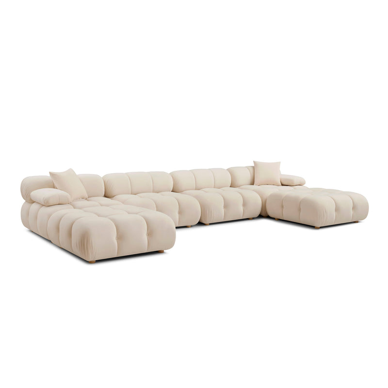 Cream modular sectional sofa with chaise end, tufted cushions, and two back pillows