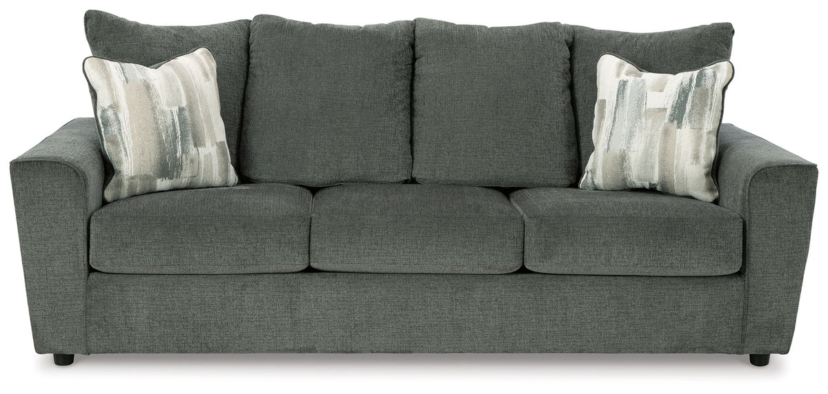 Grey fabric sofa with three seat cushions, rolled arms, and two patterned throw pillows.