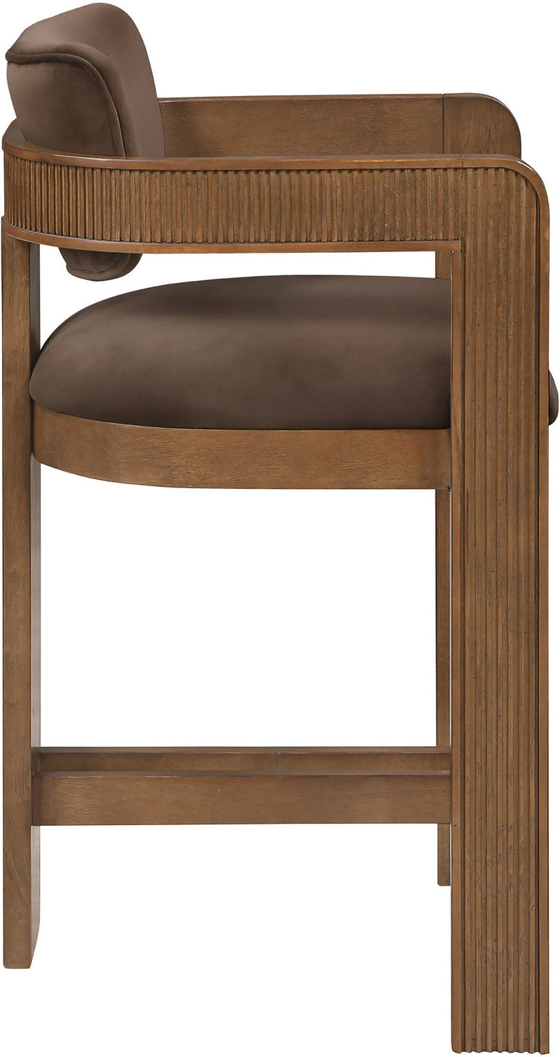 Brown wooden velvet stool with dark brown seat and back, curved top, and slat sides