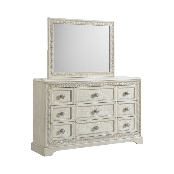 White dresser with ornate mirror, nine drawers with round metal knobs.