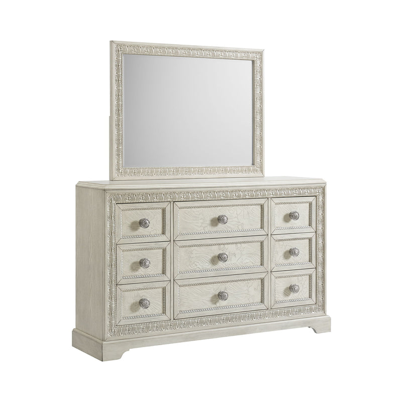 White dresser with ornate mirror, nine drawers with round metal knobs.
