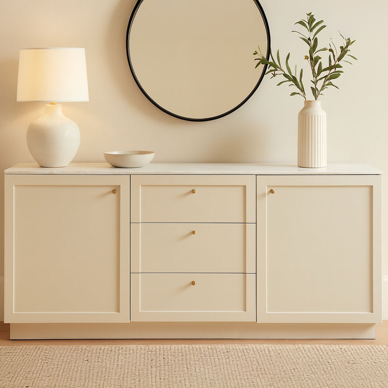 Cream sideboard with two cabinet doors and three central drawers, gold knobs