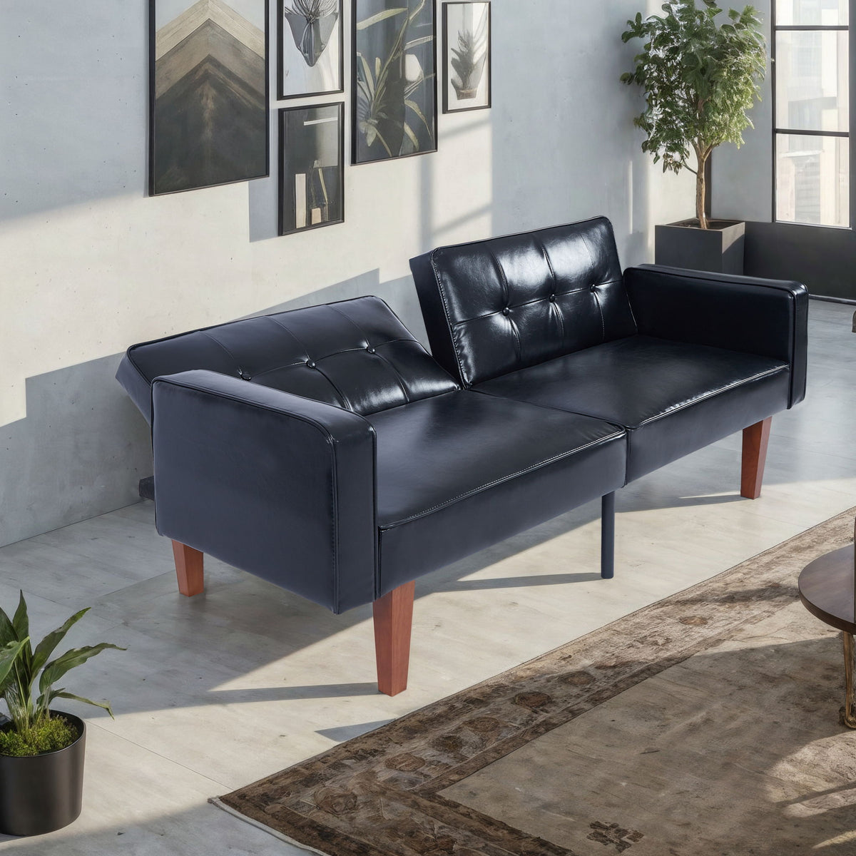 Black split-back futon sofa bed with tufted back cushions and padded armrests