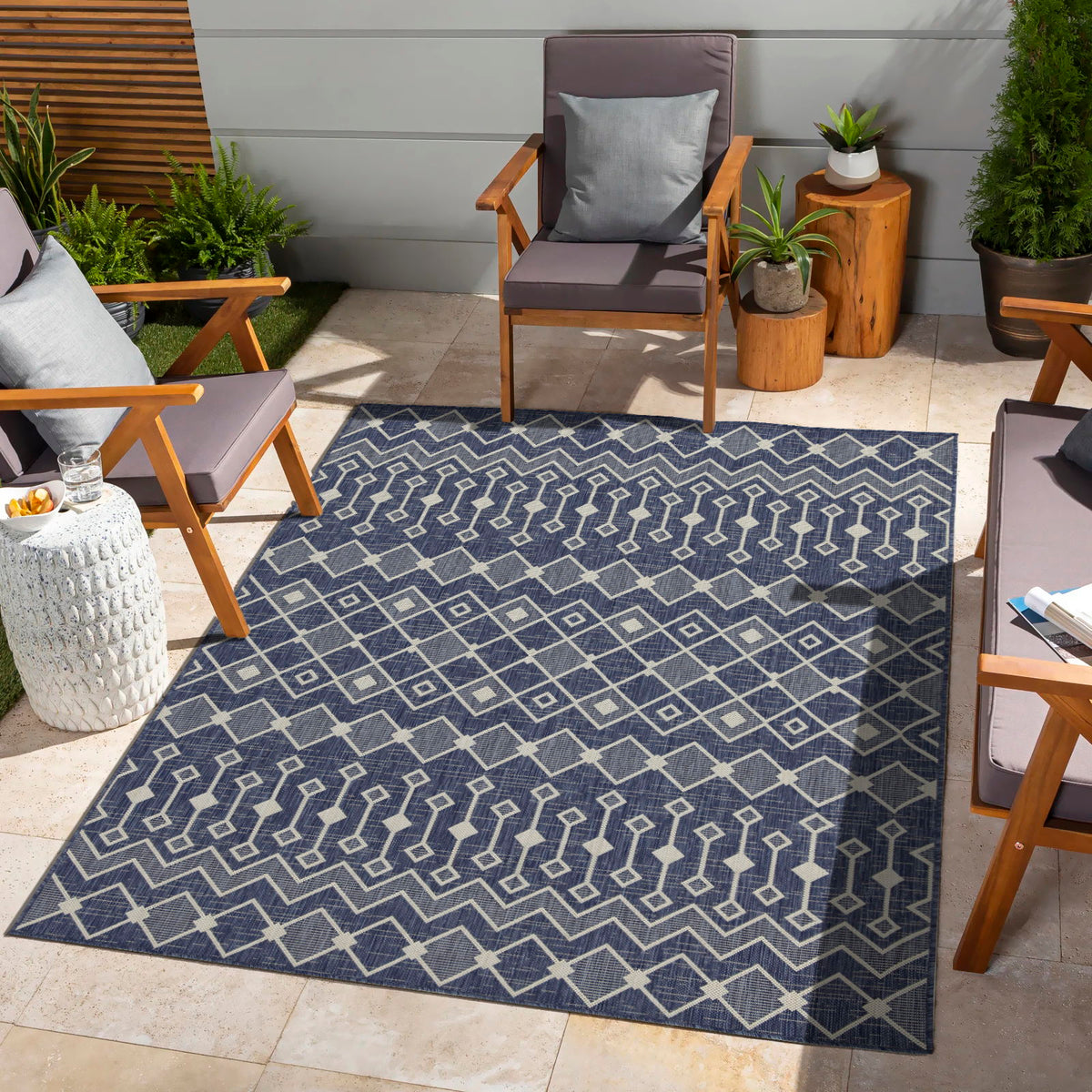 Indoor/outdoor polypropylene area rug, navy with white geometric diamond and zigzag pattern.