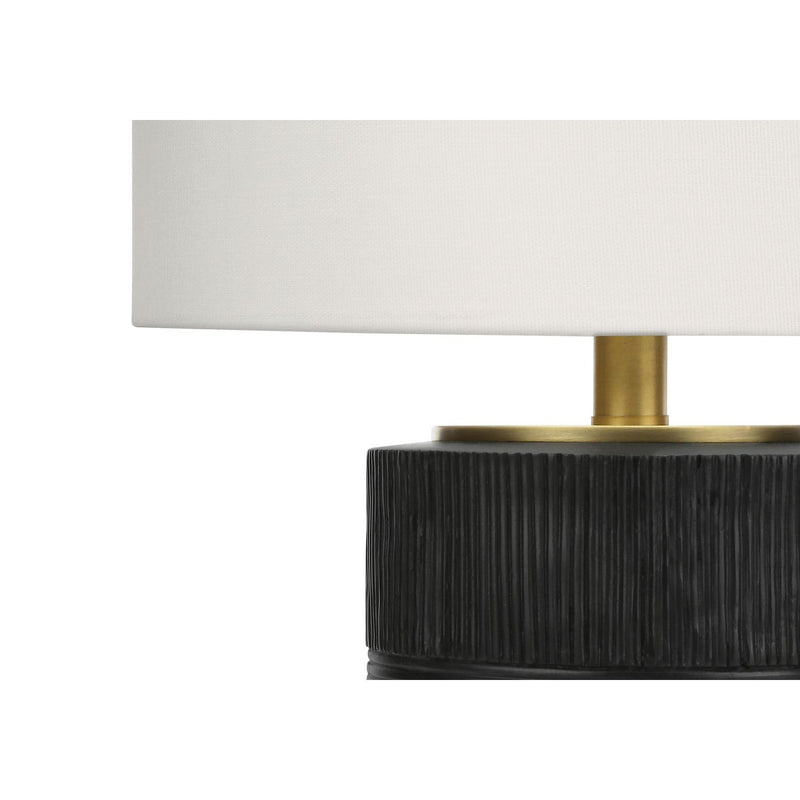 Close-up of black ribbed resin table lamp base with cream fabric shade