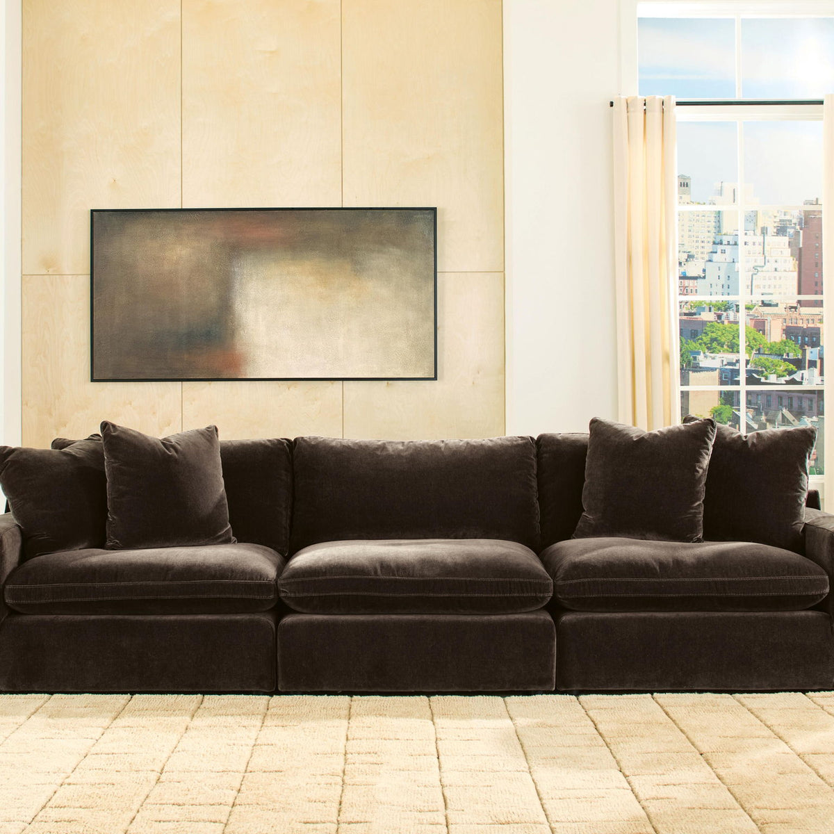 Dark brown 3-seat sectional sofa with four accent pillows in an open room