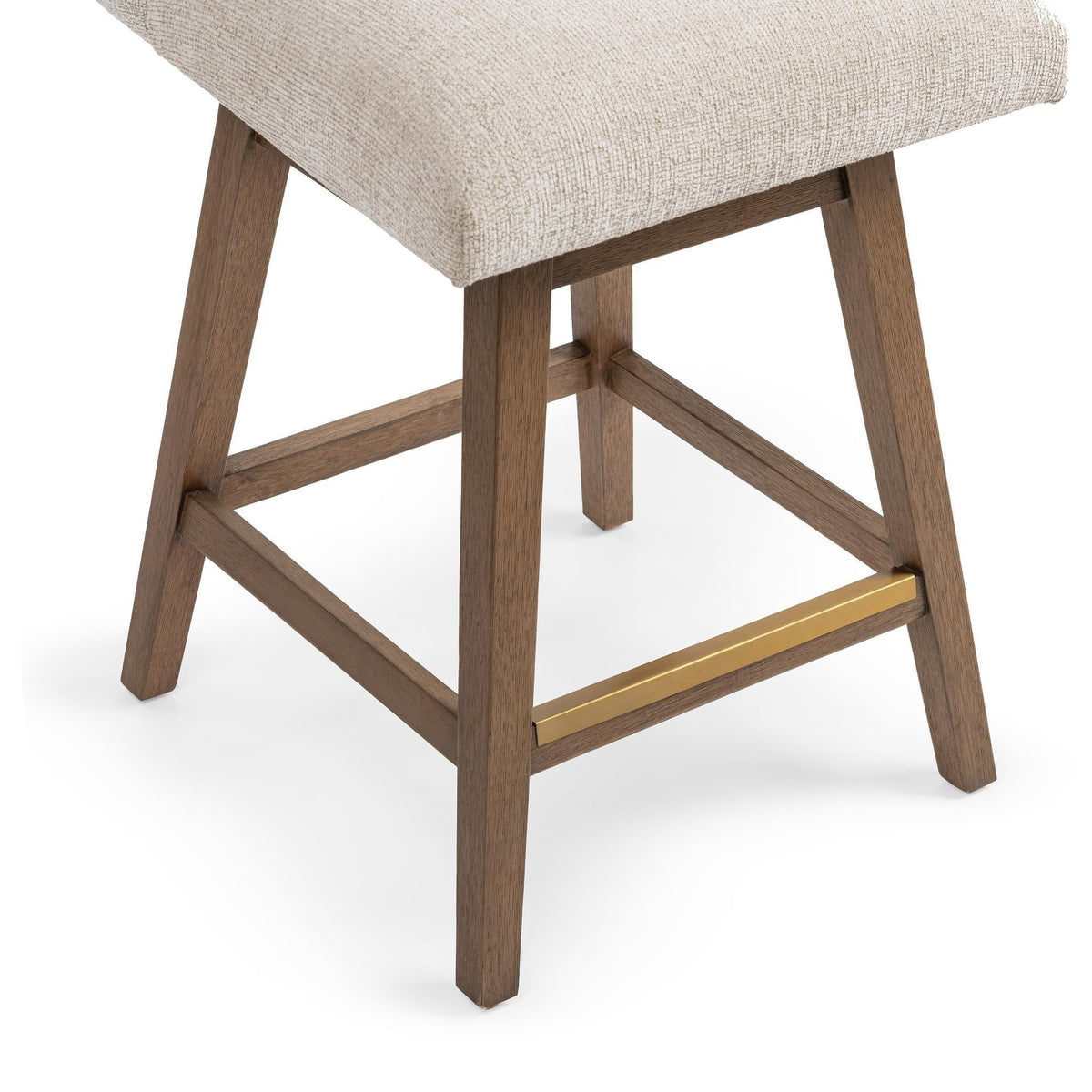 Counter-height swivel stool base detail with light beige upholstery, wooden legs and gold-tone stretcher.