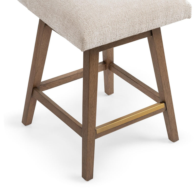 Counter-height swivel stool base detail with light beige upholstery, wooden legs and gold-tone stretcher.