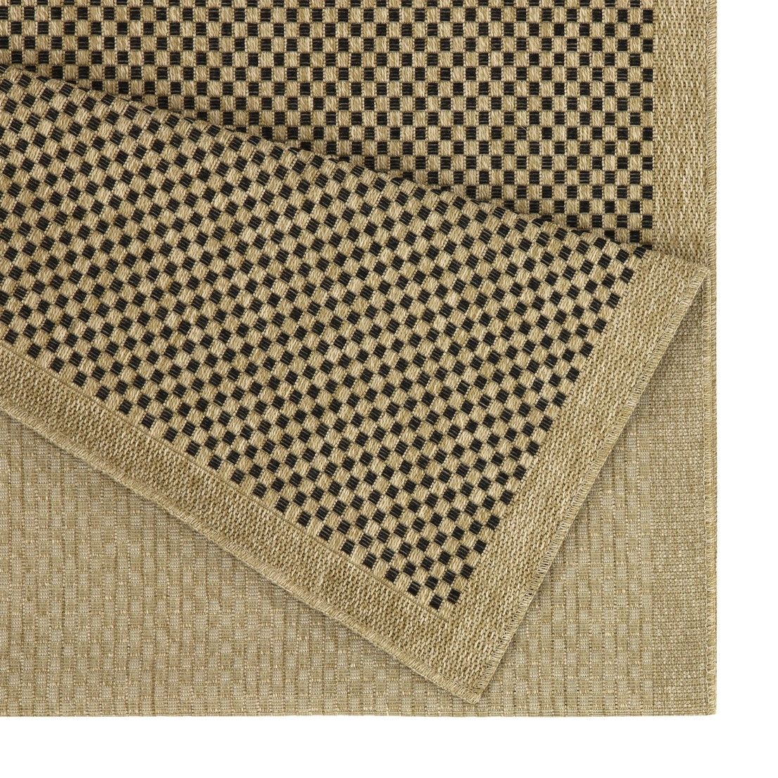 Light brown area rug corner detail with black-and-brown check border and textured weave