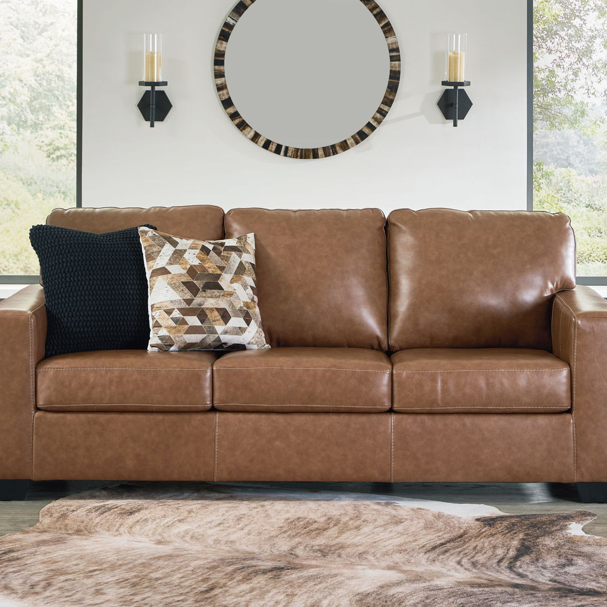 Brown upholstered sofa with three seat sections and two decorative pillows