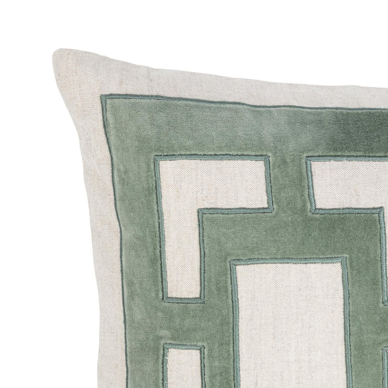 Close-up of light beige pillow with green geometric applique front