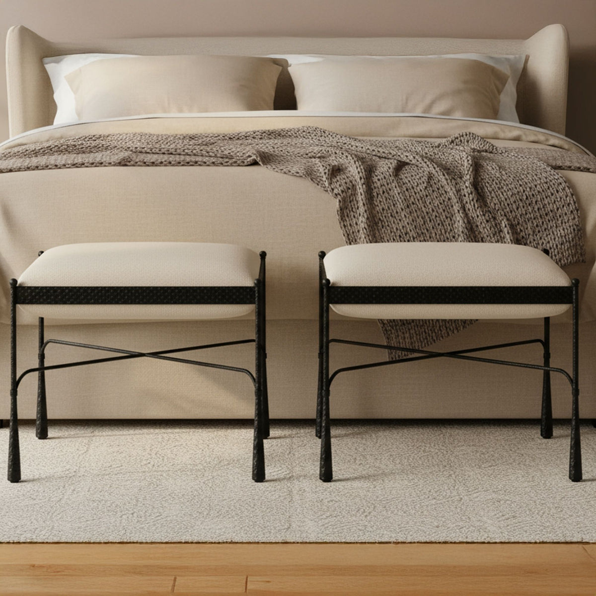 Two cream upholstered stools with black metal legs, placed side by side