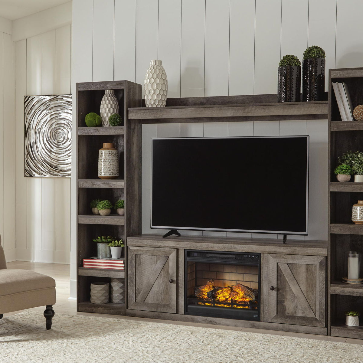 Gray entertainment center with wide TV opening, shelving, and built-in faux fireplace