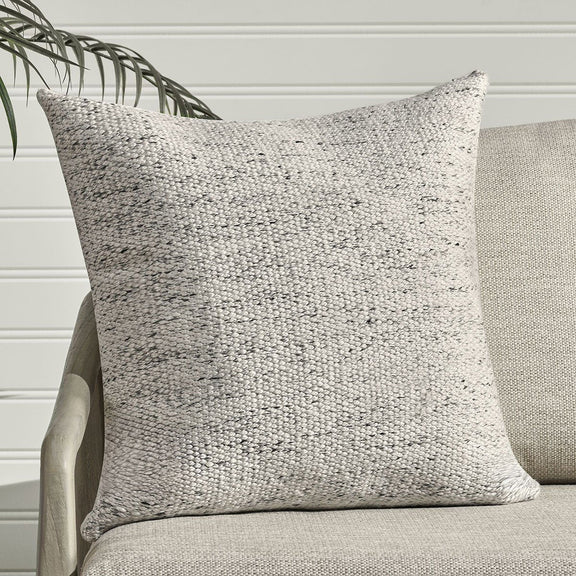 Textured woven lumbar pillow, off-white with light speckling and piped edges