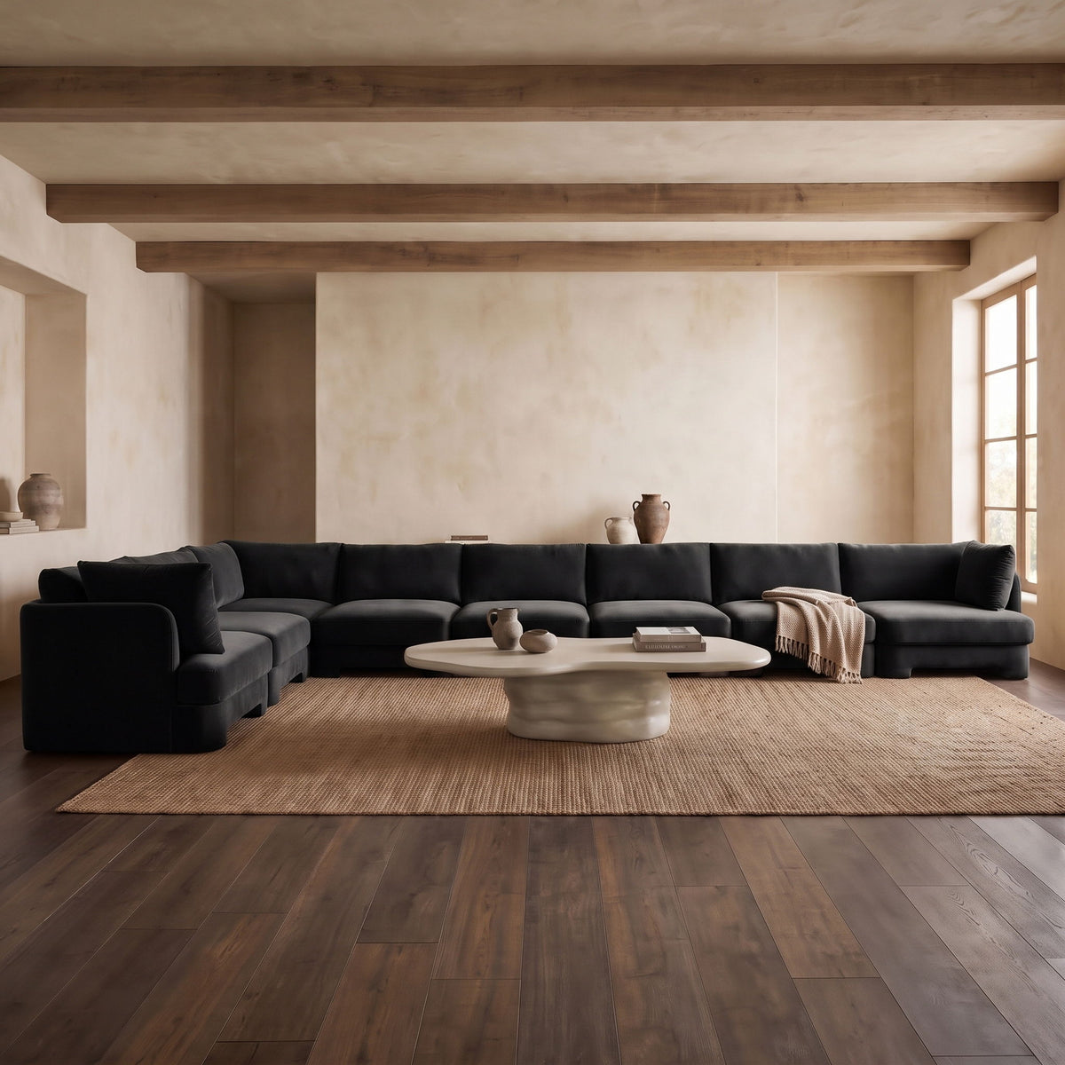 Black L-shaped velvet sectional sofa with chaise lounge and coordinated throw pillows