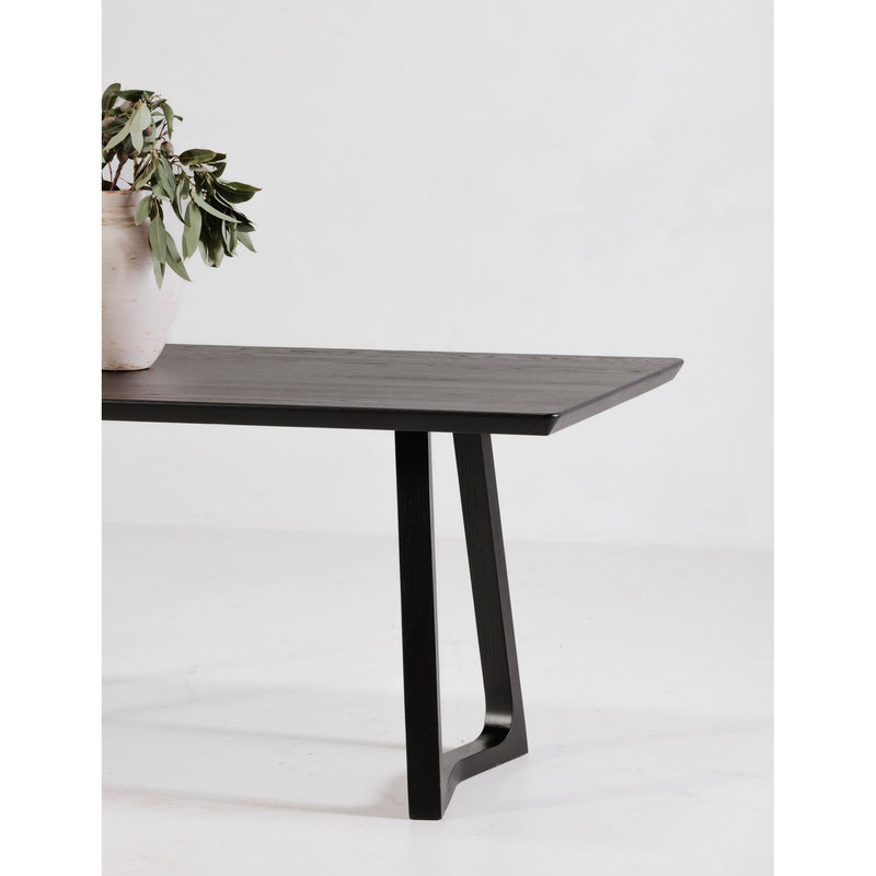 Black ash dining table with rectangular top and pedestal base, side angle