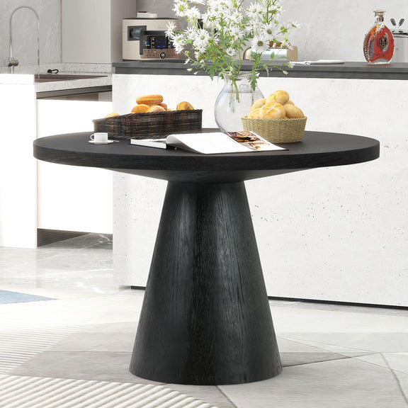 Black round pedestal dining table with a wide, smooth top