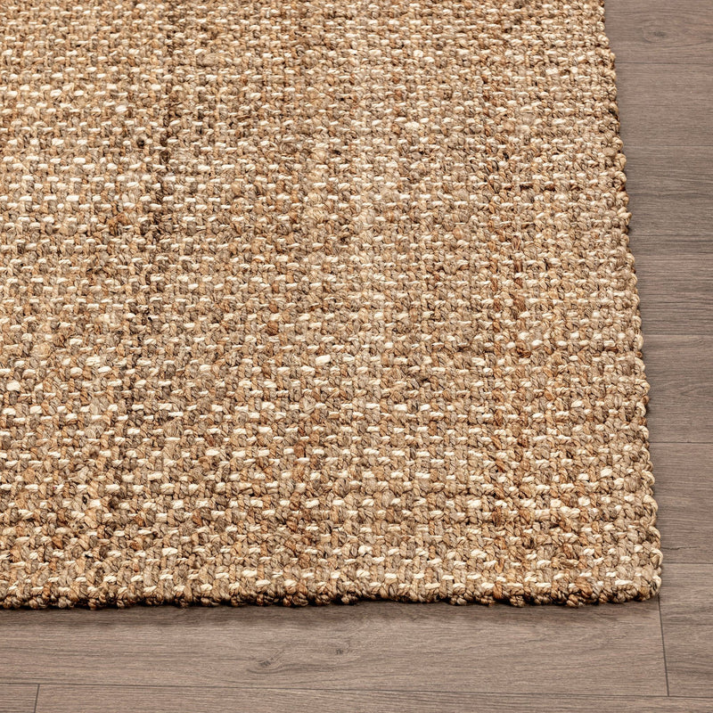 Jute rug corner detail with open weave texture and short braided fringe