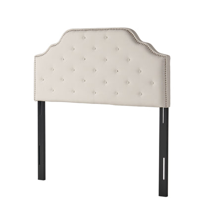 Beige upholstered twin-size headboard with button tufting and nailhead trim, curved top
