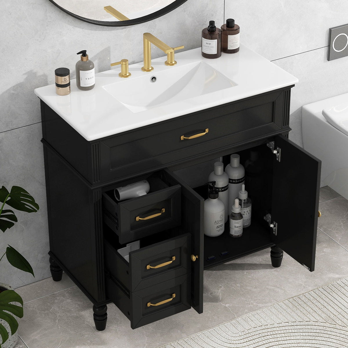 Black bathroom vanity with white sink top, open drawers and shelves, gold hardware