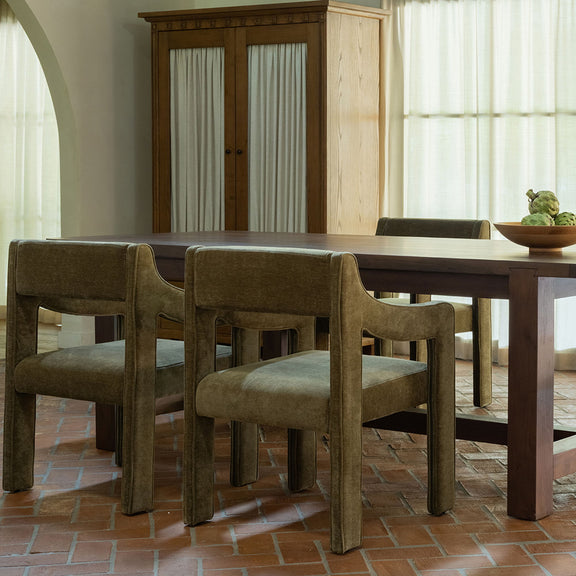Warm brown dining table with straight legs and gray upholstered dining chairs.