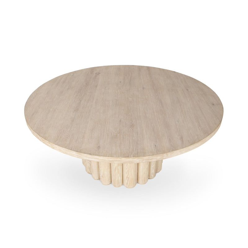 Cream washed round dining table with scalloped pedestal base and light wood grain.