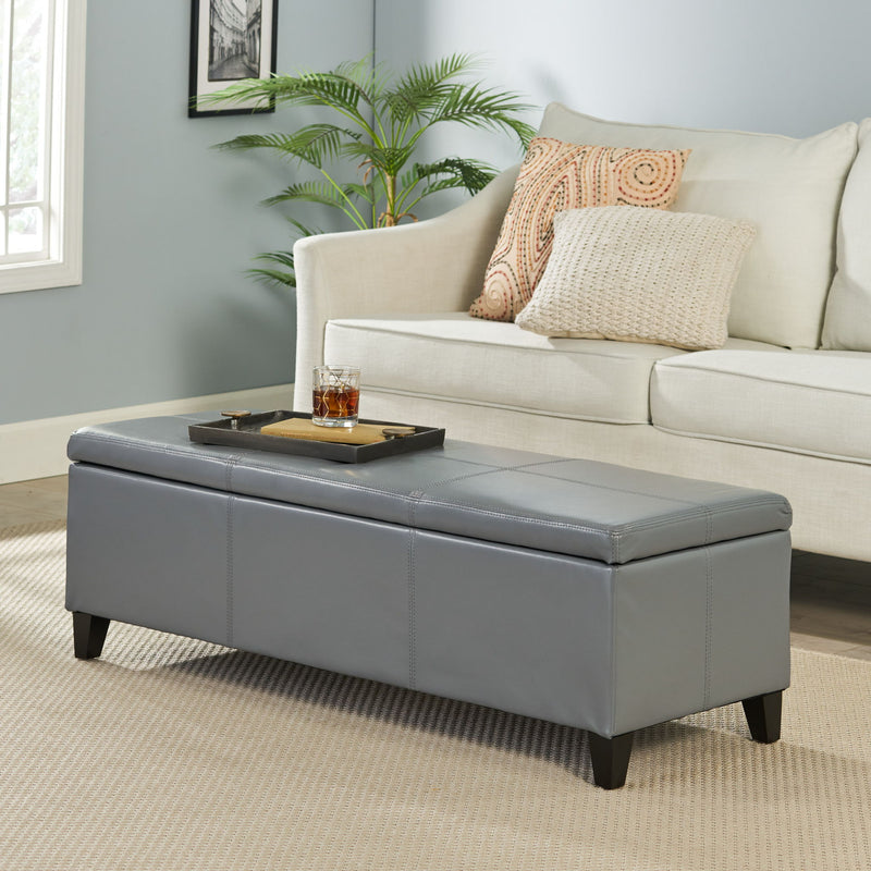 Dark gray storage ottoman with padded top and stitched sides