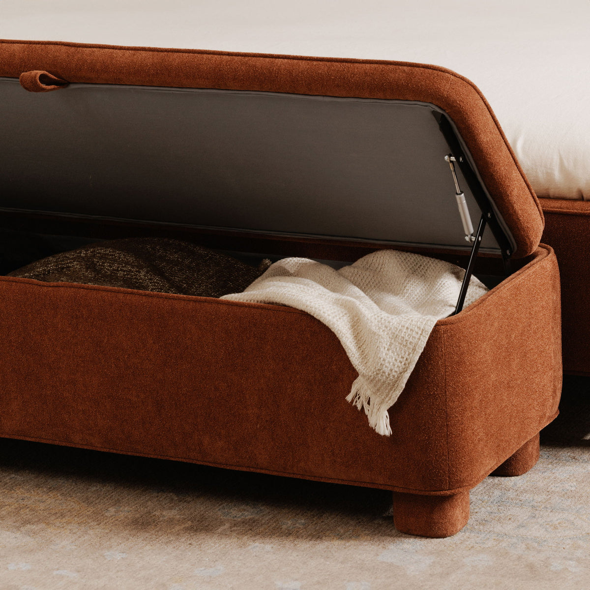 Deep orange storage bench with open hinged lid and fabric-lined interior