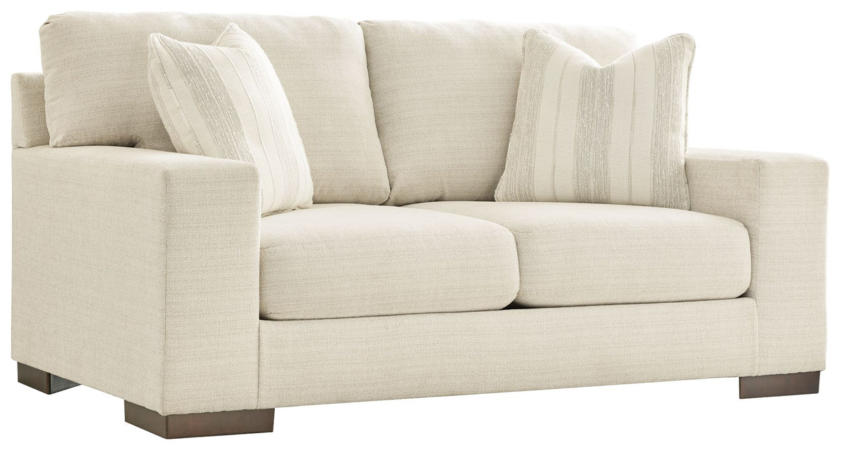 Cream fabric loveseat with two seat cushions and two striped throw pillows