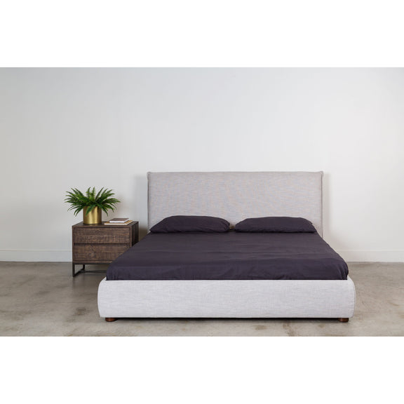 Light gray king bed with dark duvet, two pillows, and upholstered headboard