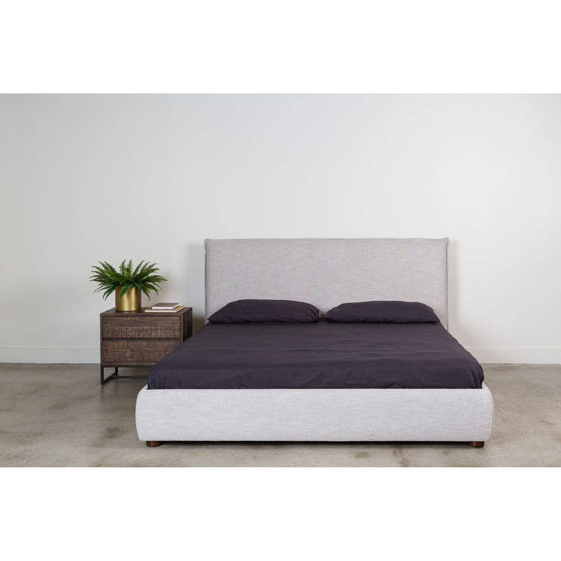 Light gray king bed with dark duvet, two pillows, and upholstered headboard
